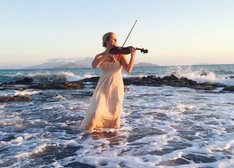 Frau spielt Geige im Meer